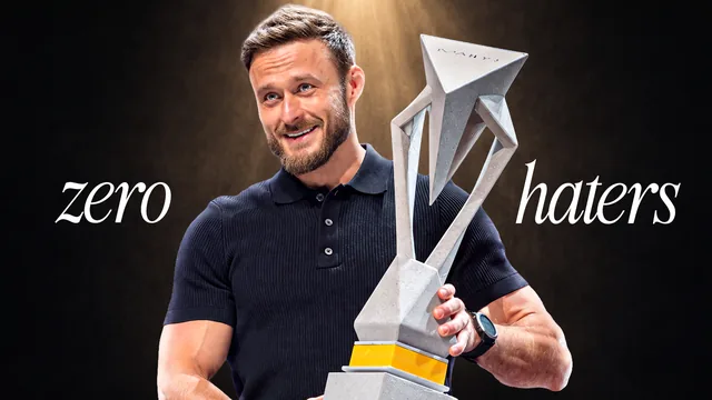 Man holding a trophy between the words zero and haters
